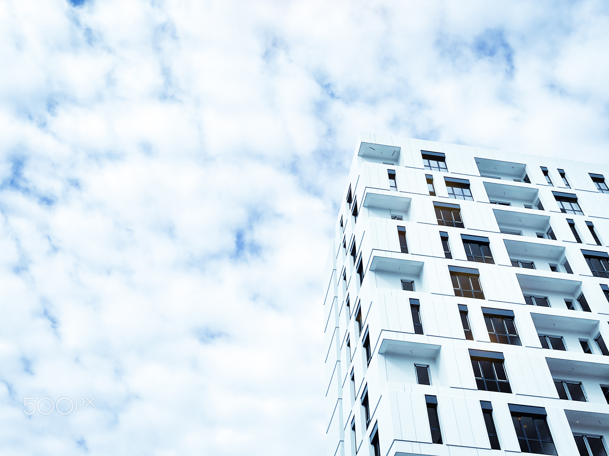 Image of a building under construction with cloudy sky background.