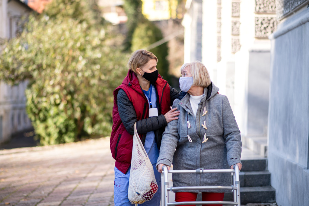 Senior woman with walking frame and caregiver outdoors in town by Jozef Polc on 500px.com