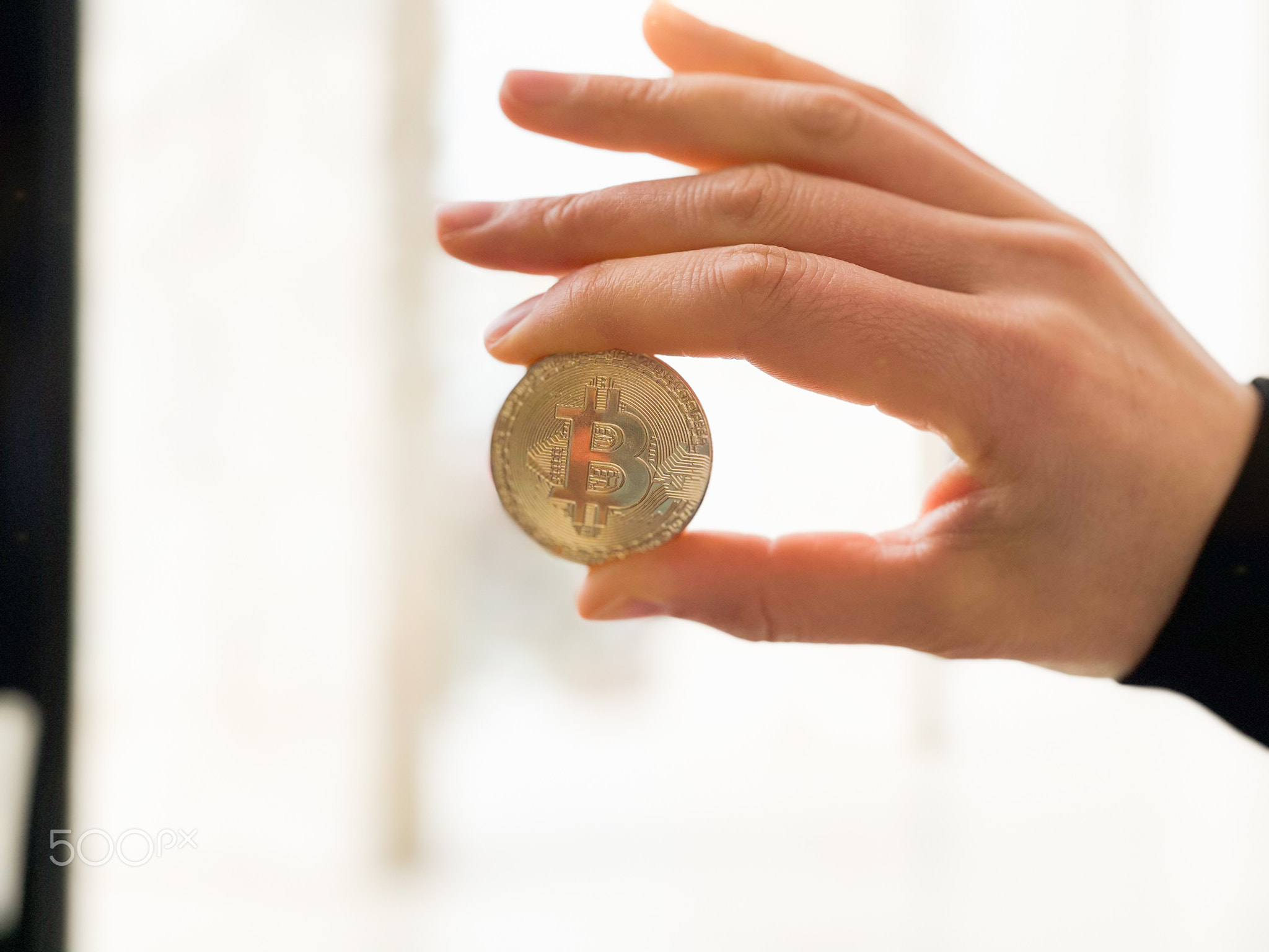 Female holding in her hand symbol of crypto currency .