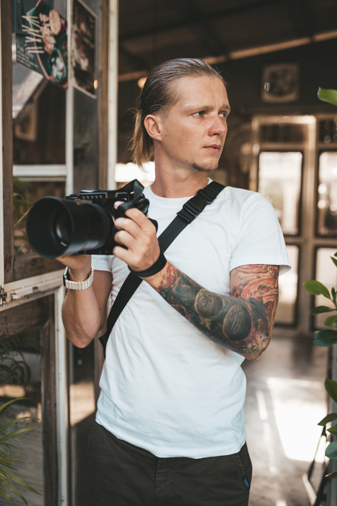 Man photographer holding his camera by Natalie Zotova on 500px.com