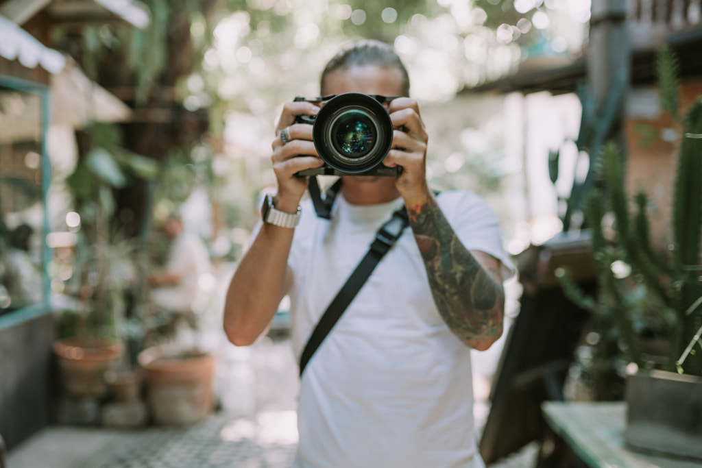 Man photographer holding his camera by Natalie Zotova on 500px.com