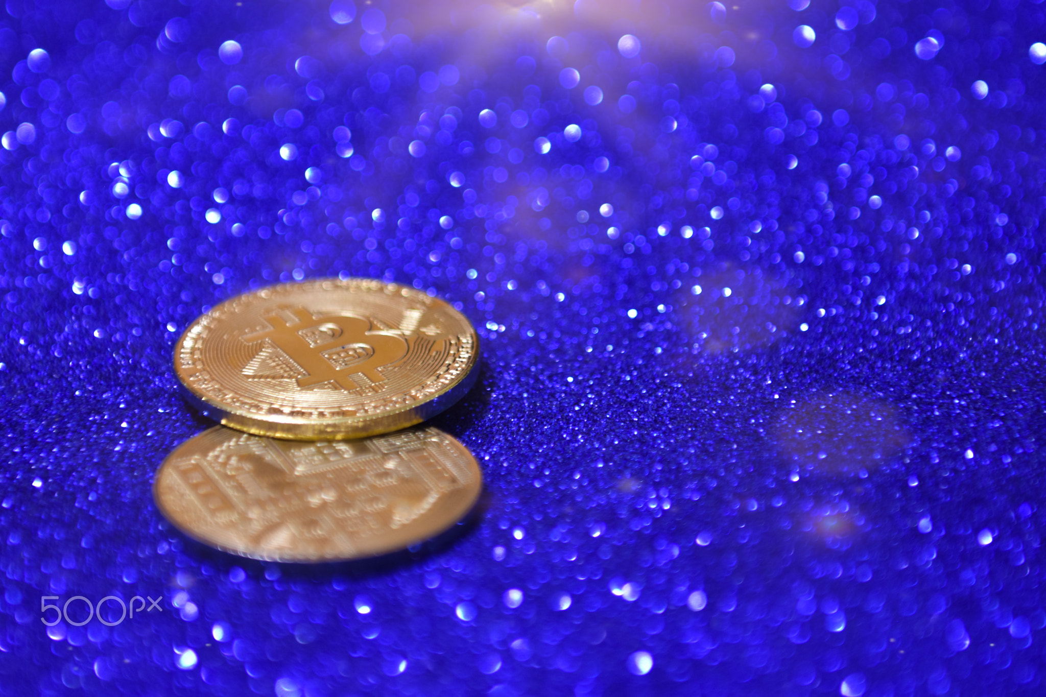 Golden bitcoin coin with glitter lights background