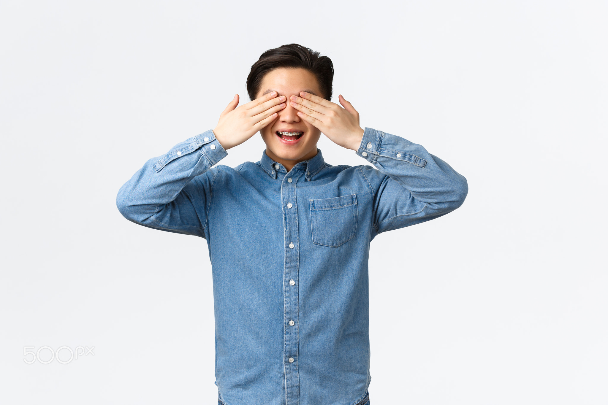 Excited happy asian man with braces, smiling amused as anticipating