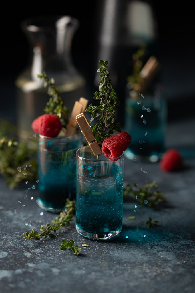 Set of cocktails in shot glasses with blue liqueur,thyme sprigs and by Olga on 500px.com