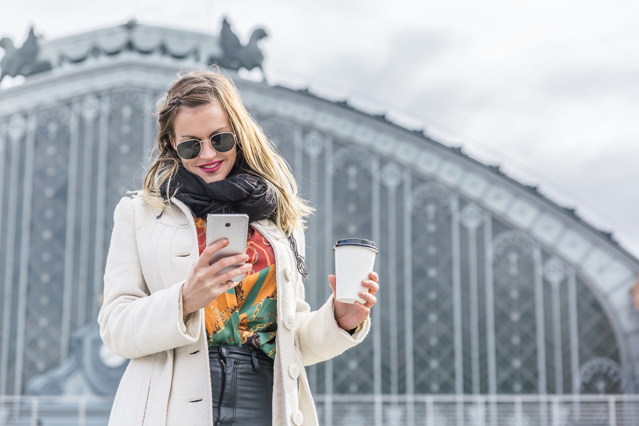 Attractive businesswoman with white coat and black pants looks