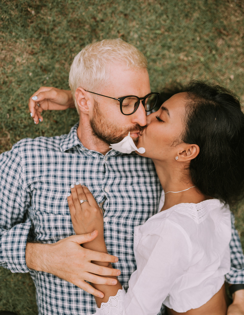 Multinational couple of asian woman and blonde man laying on the grass by Natalie Zotova on 500px.com