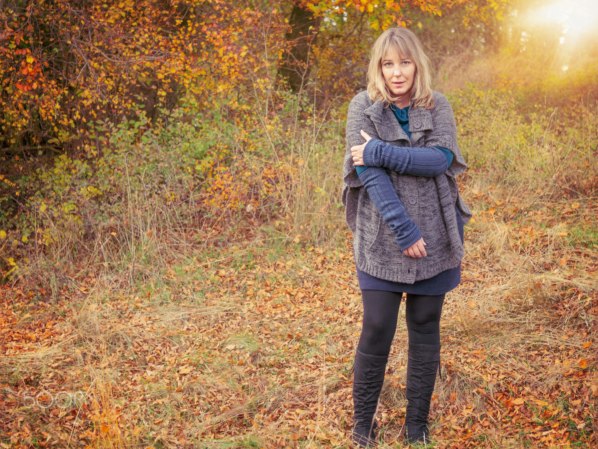 Frau blickt kess in Herbstlandschaft