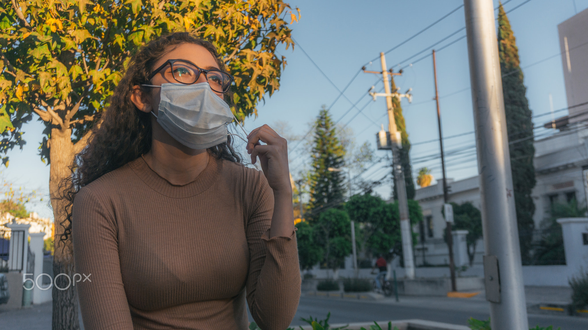 Woman with masks seated on the street