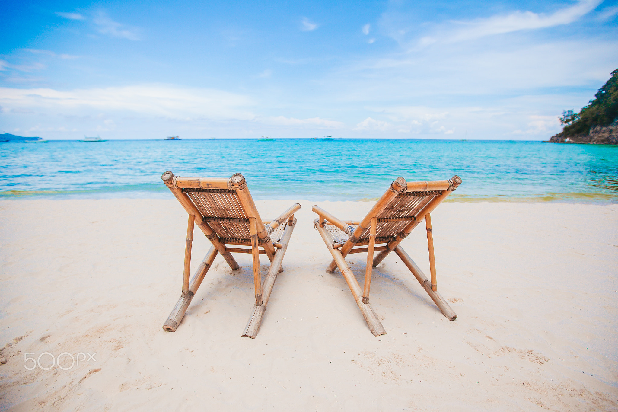 White lounge chairs on a beautiful tropical beach