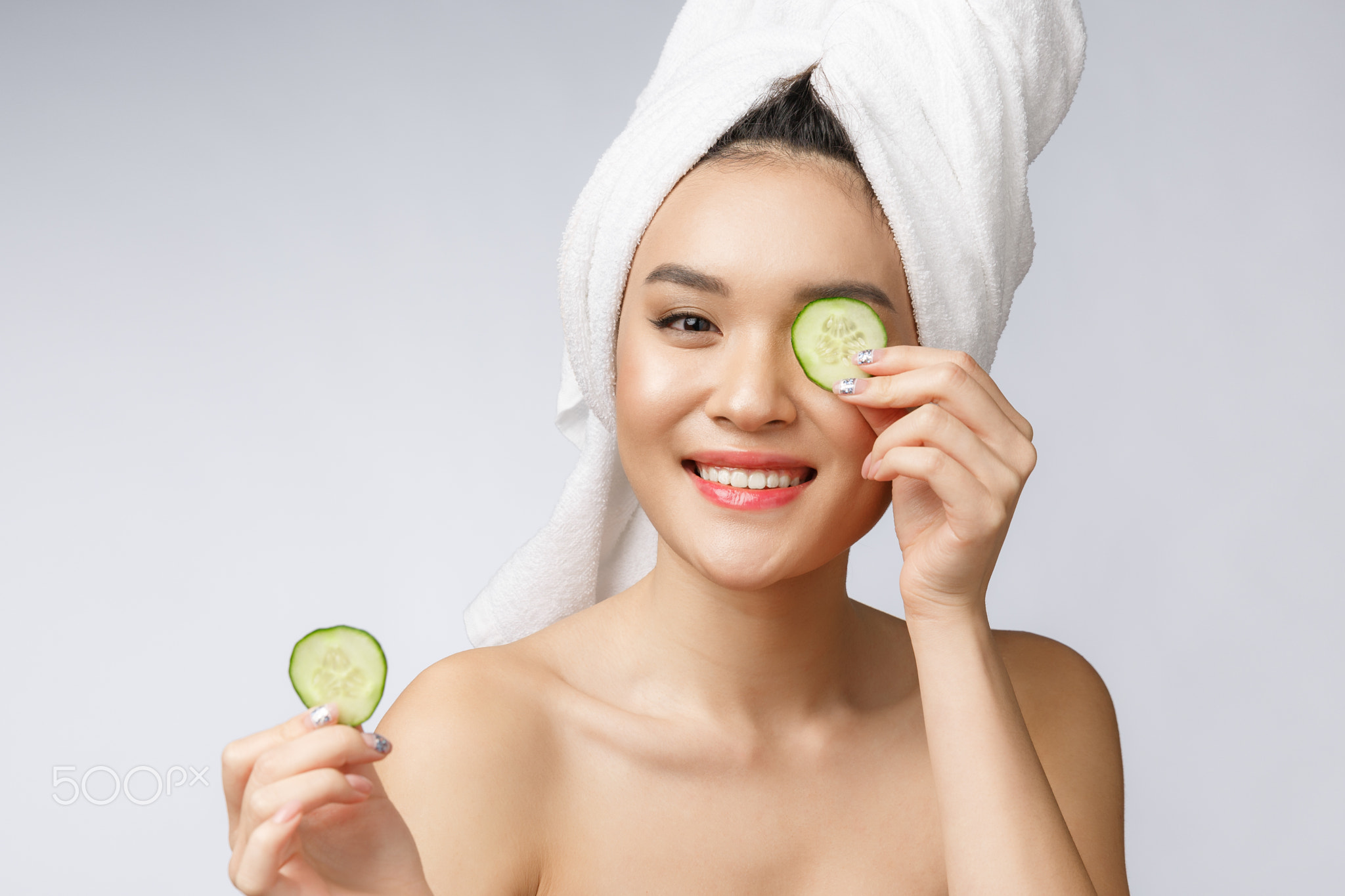 Beauty young asian women skin care image with cucumber on white