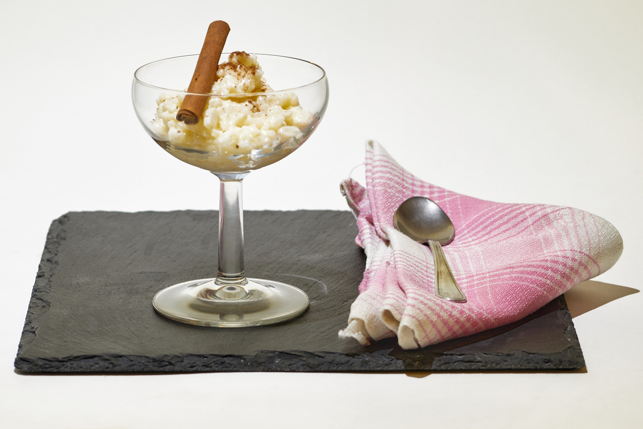 Rice pudding glass with cinnamon stick on a slate board