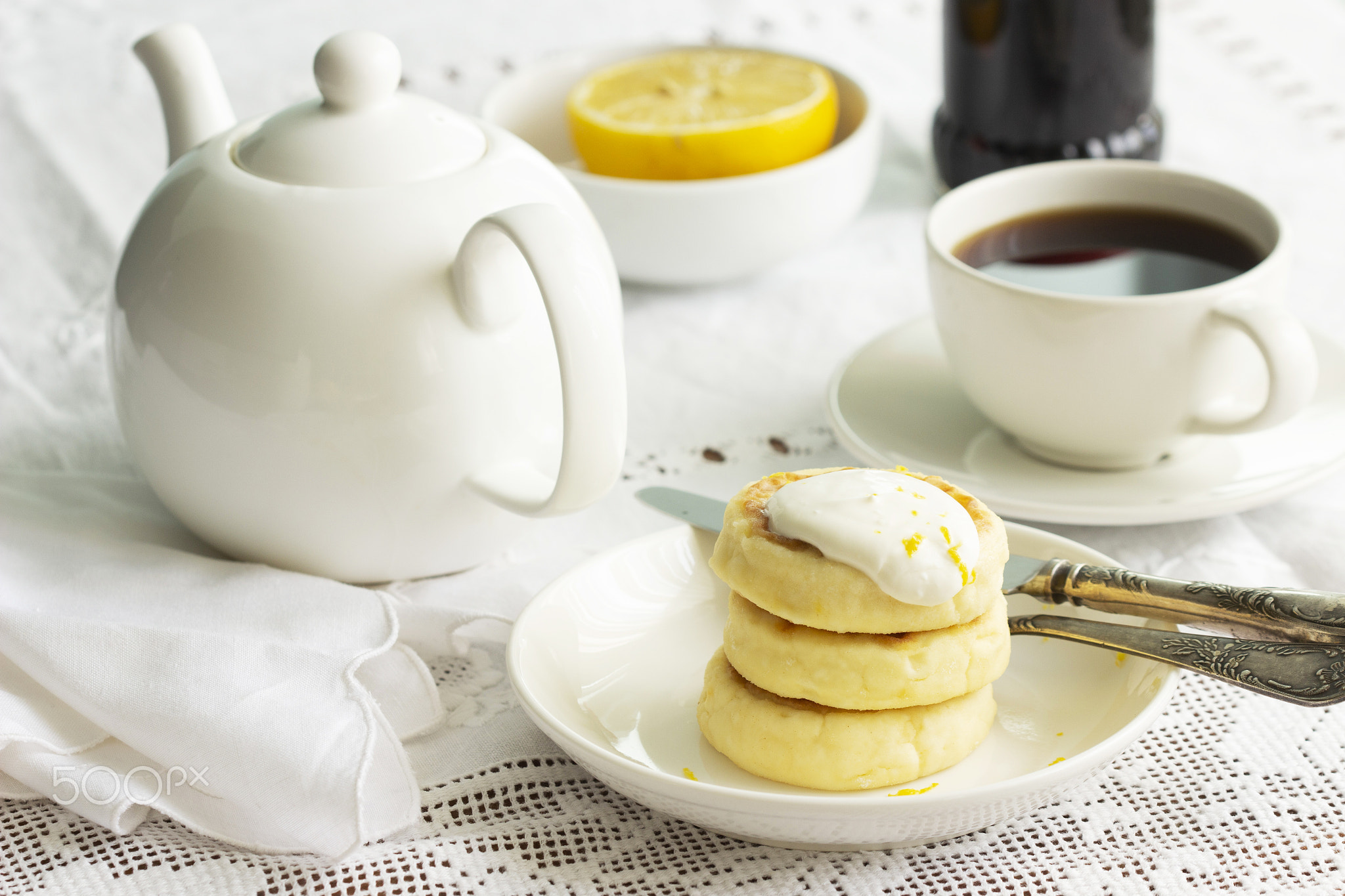 Cottage cheese pancakes with sour cream and lemon zest.