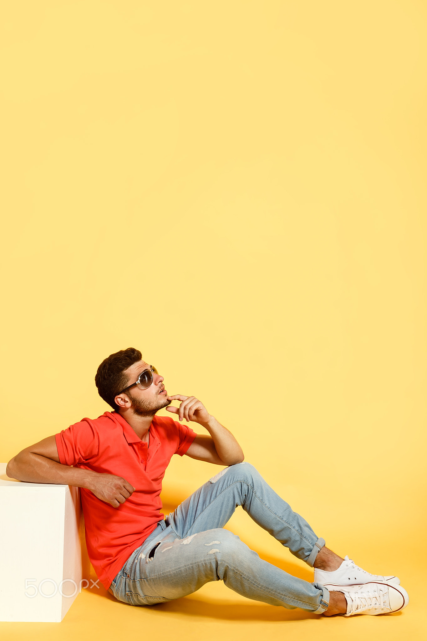 Handsome guy sitting on floor looking up