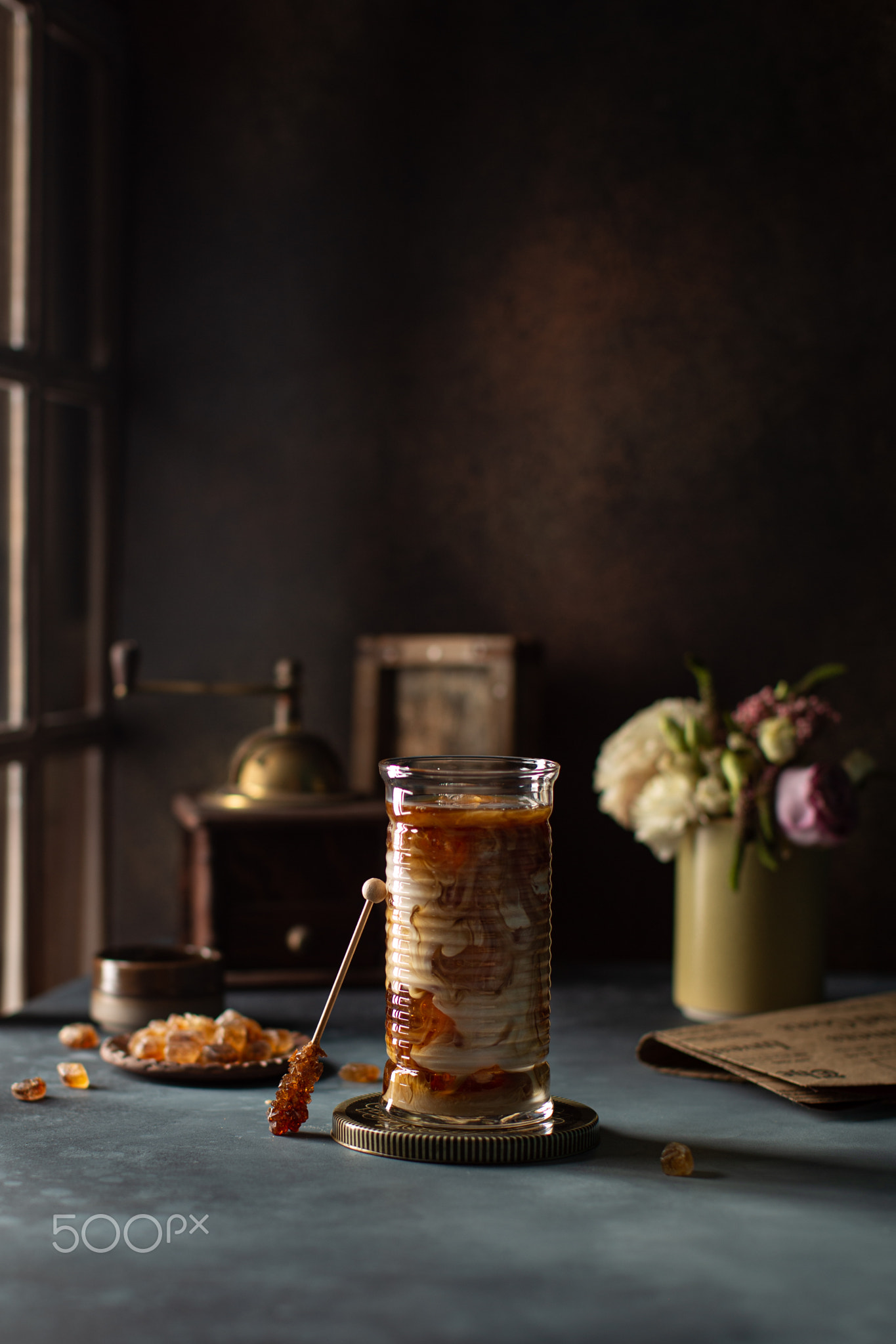 Cold coffee with milk and ice in the glass on the table,near the