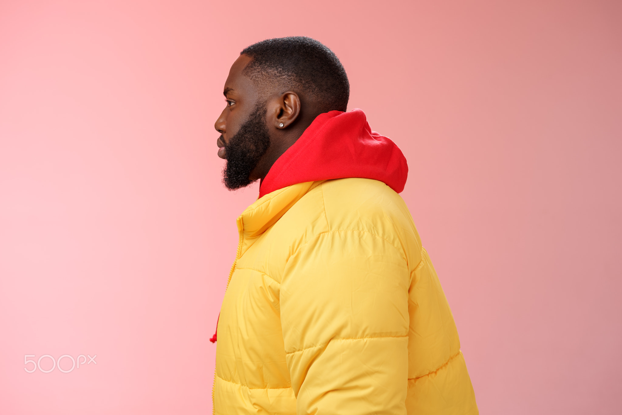 Profile studio shot bearded young 25s african guy in yellow jacket red