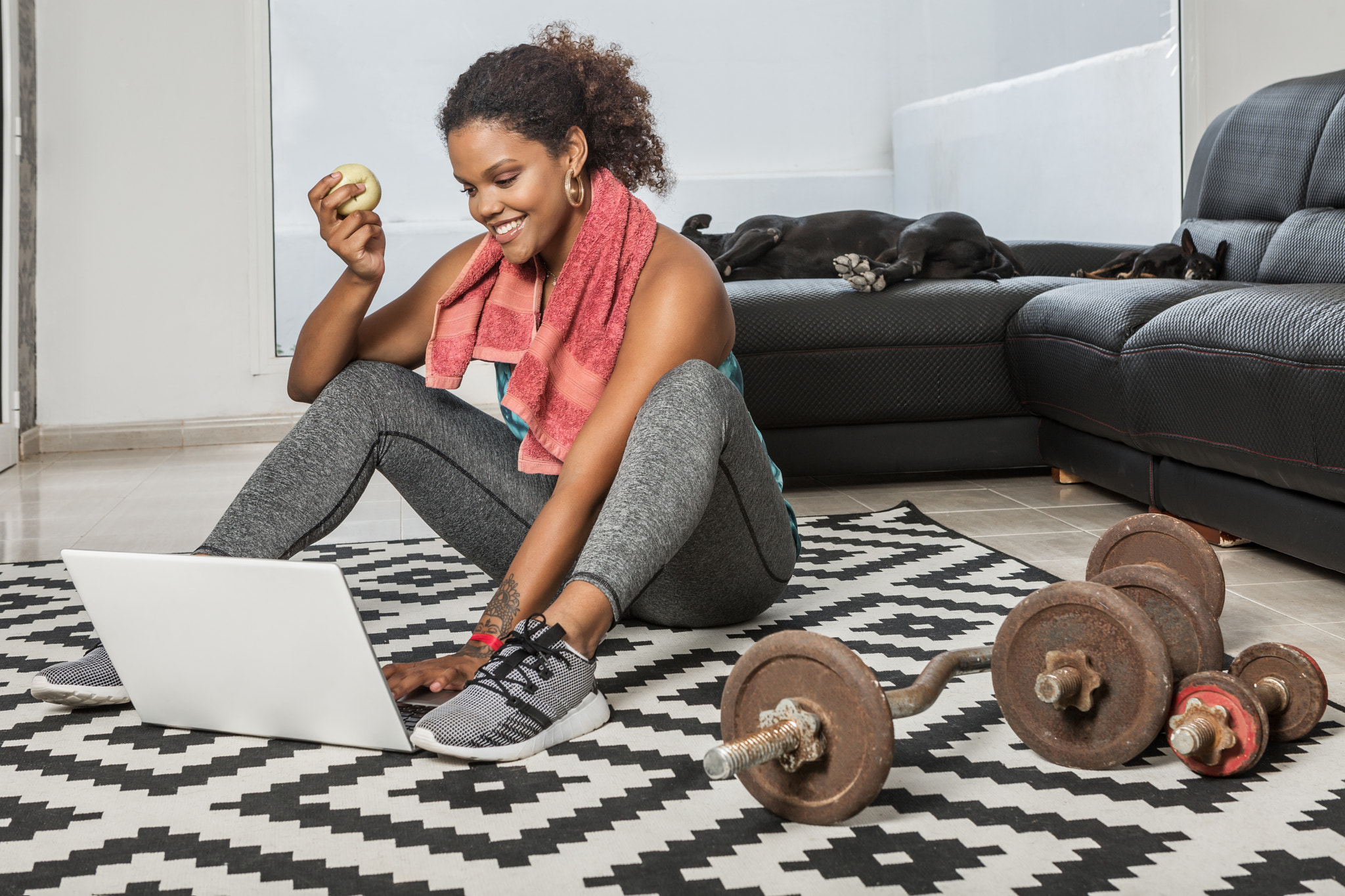 Content black sportswoman using laptop after training