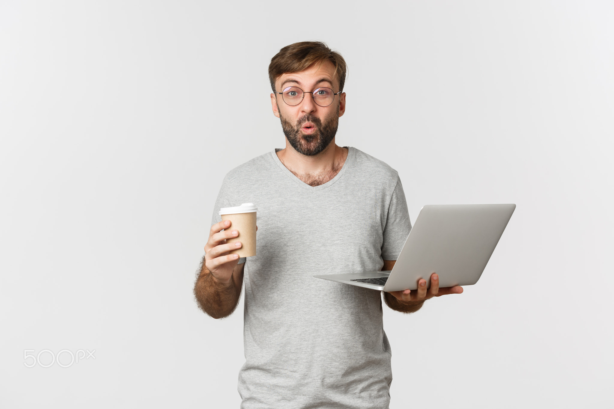 Portrait of handsome male freelancer, drinking coffee and working with