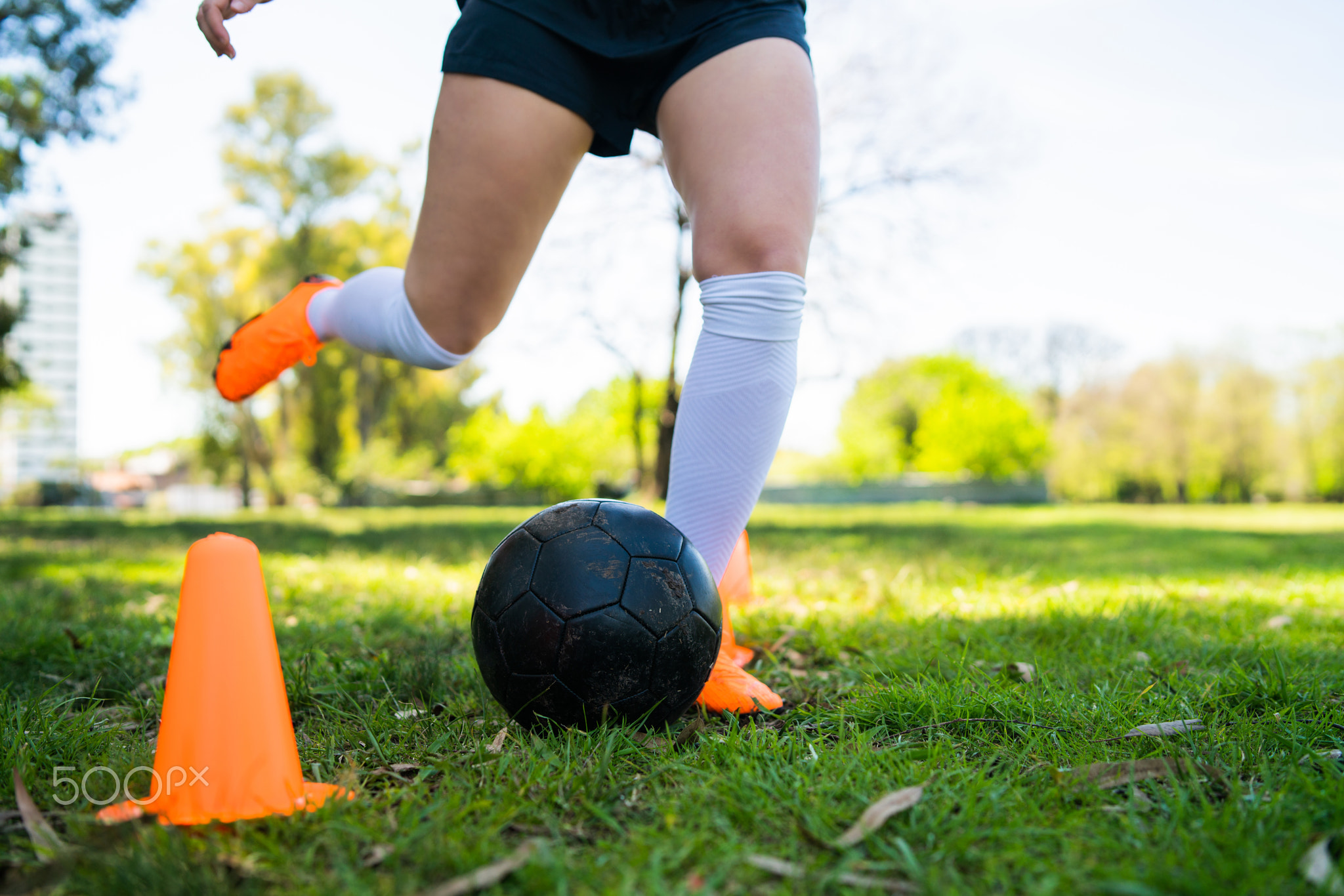 Young female soccer player practicing on field.