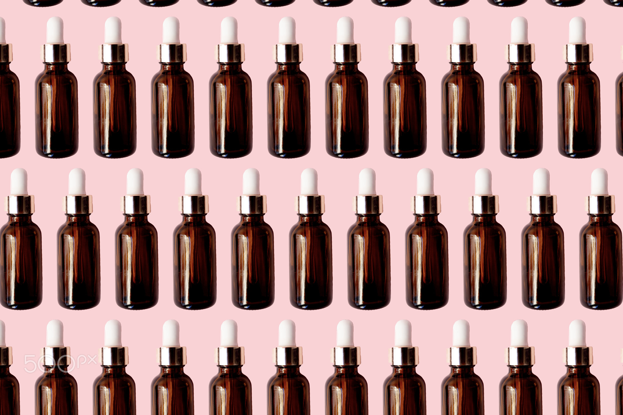 Essential oil serum glass bottle pattern isolated on pink background.