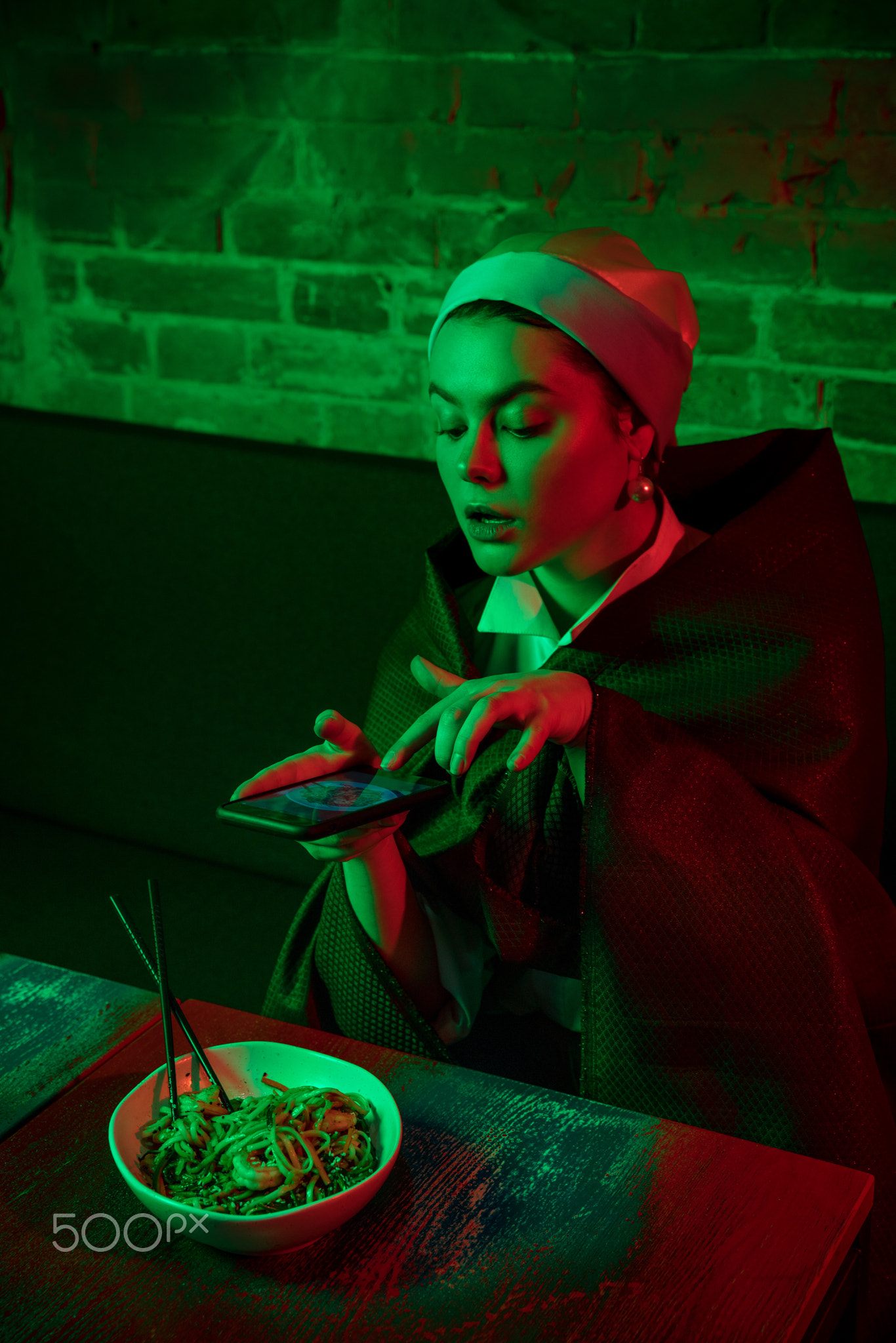 Beautiful girl with a pearl earring taking lunch in modern cafe