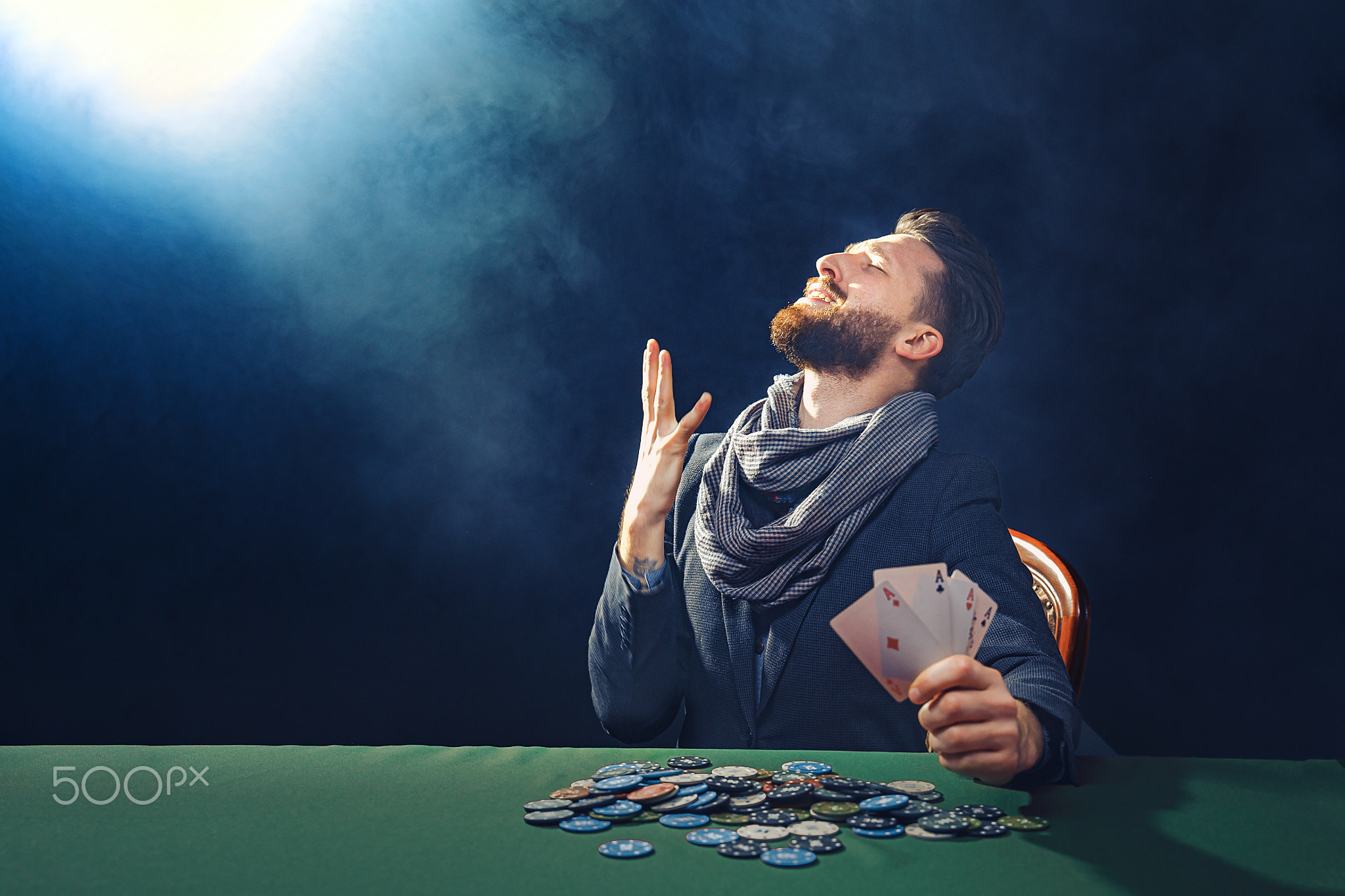 Happy poker player winning and holding a pair of aces