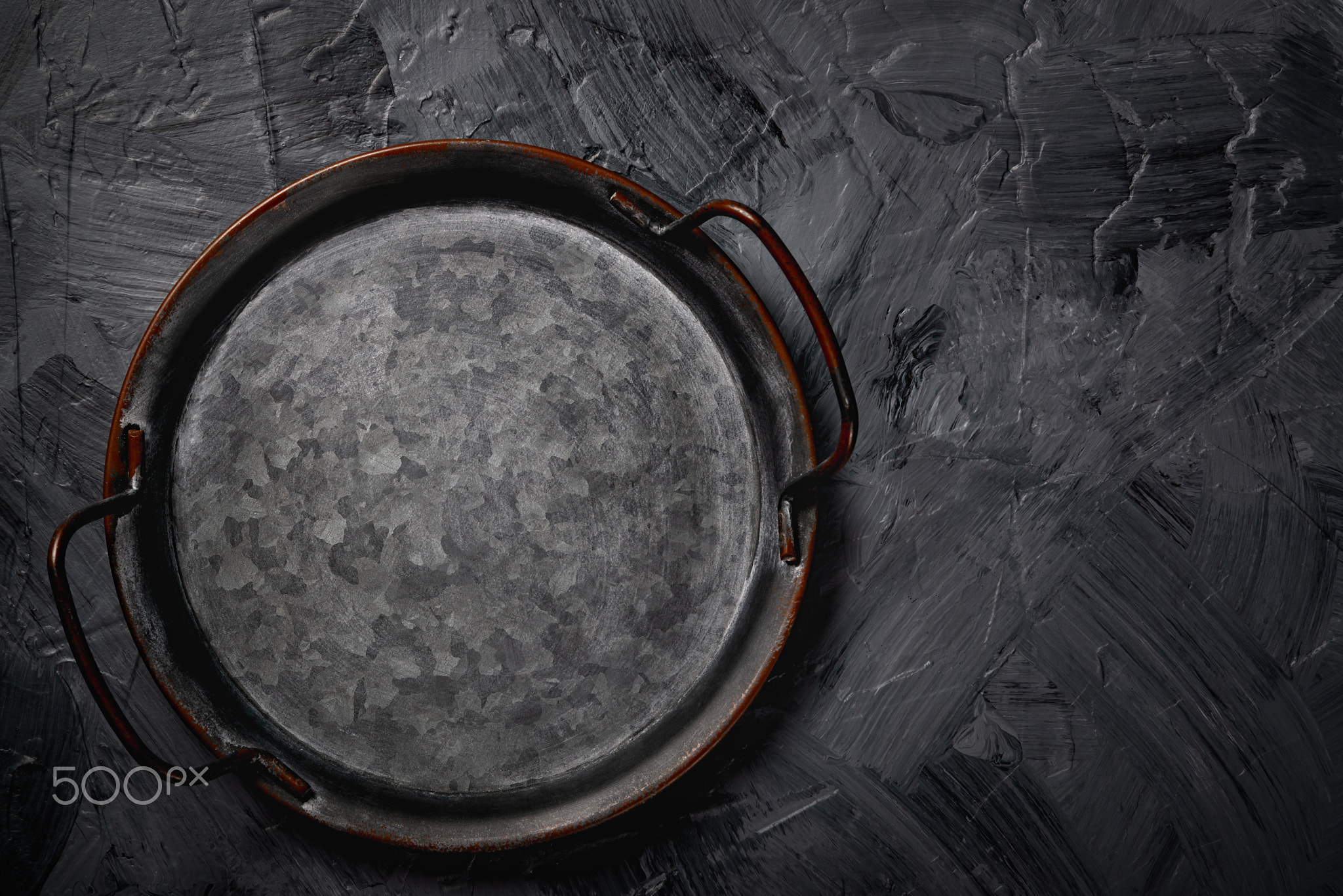 Empty metal tray on a grey background. Space for text.