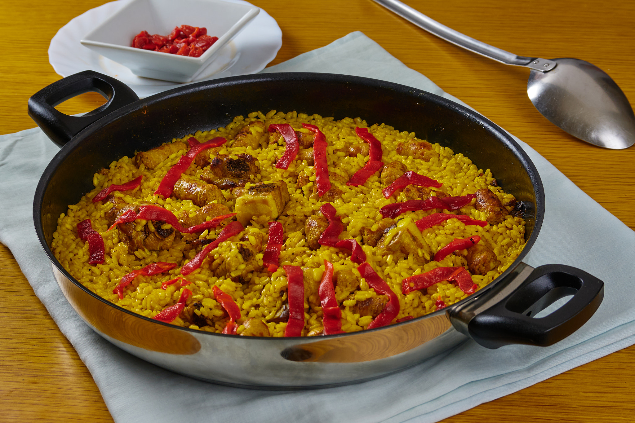 Spanish paella with meat and red peppers decorated with a red pepper