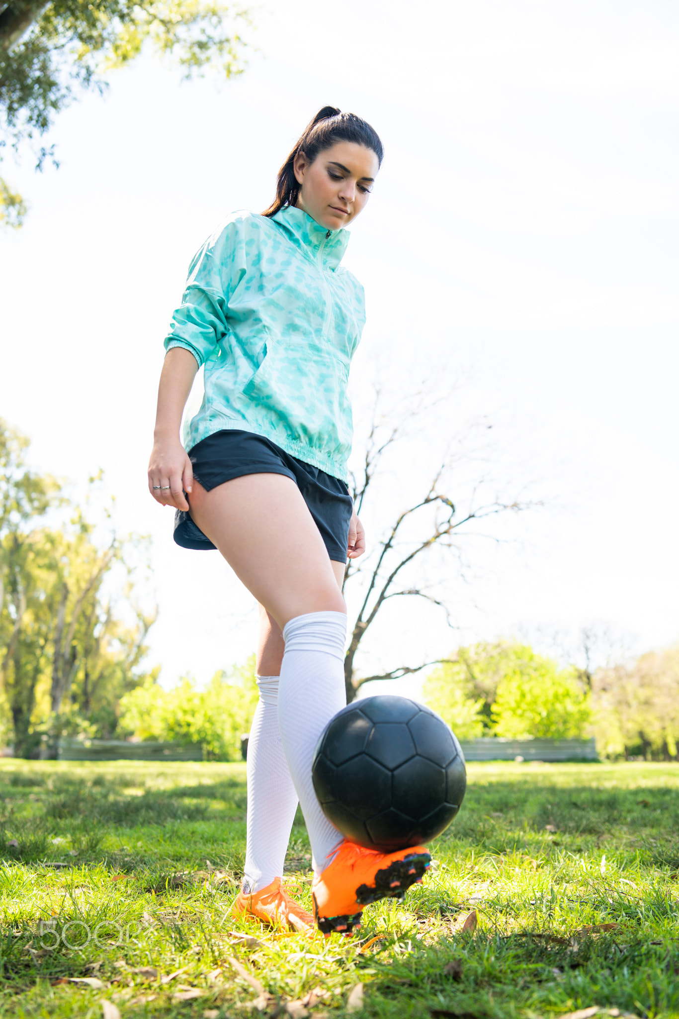 Young woman practicing soccer skills with ball.