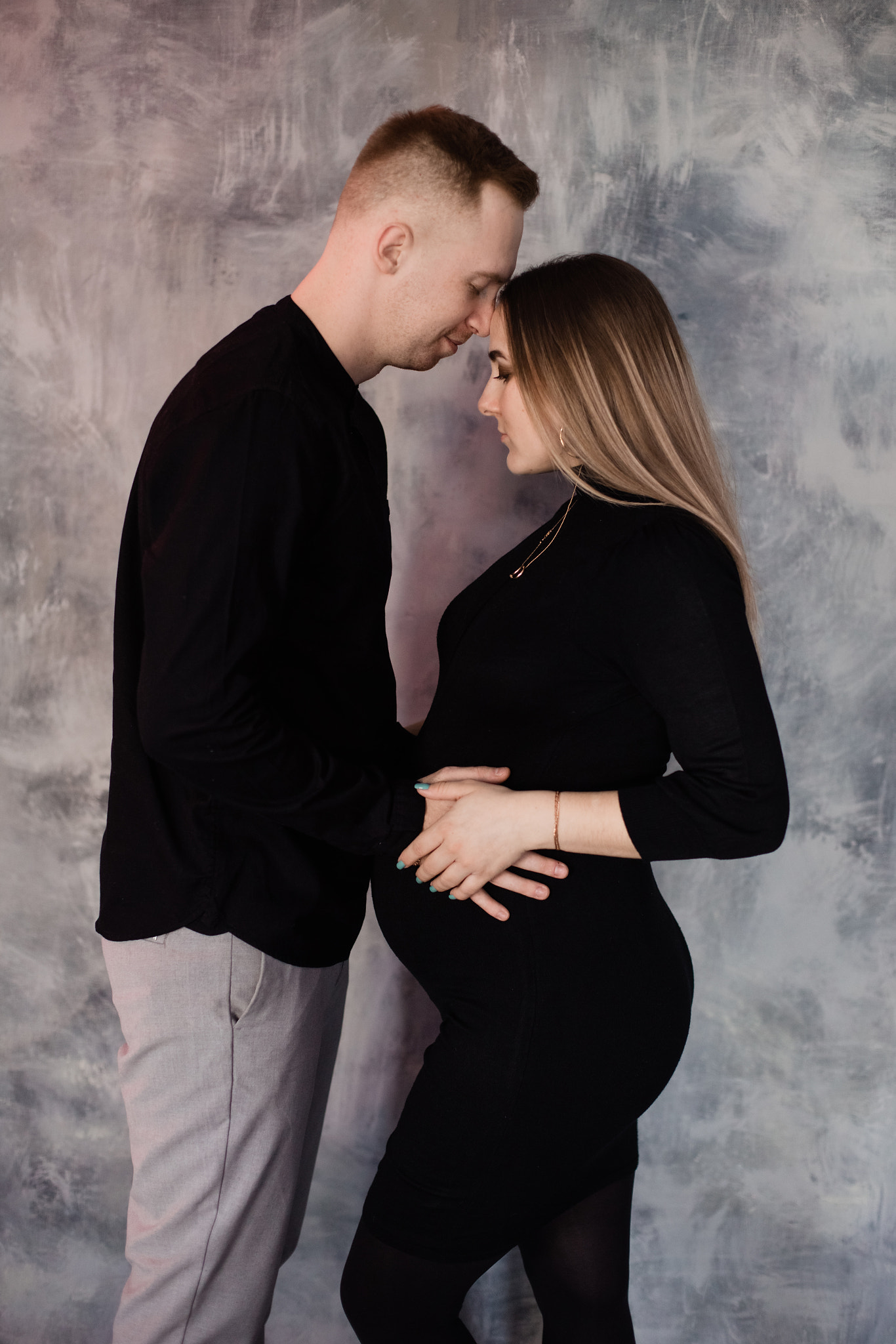 pregnant woman with her husband stand on a background Tver, Russia