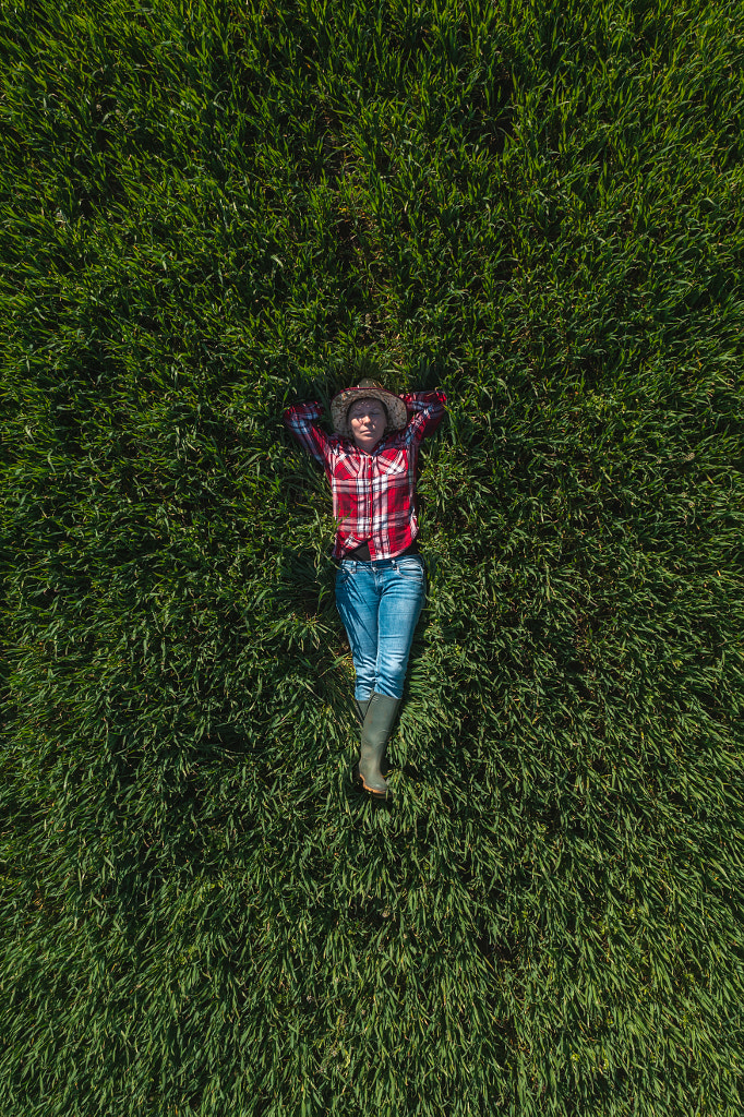 Vue aérienne d'une agricultrice posée dans un champ de blé vert par Igor Stevanovic sur 500px.com