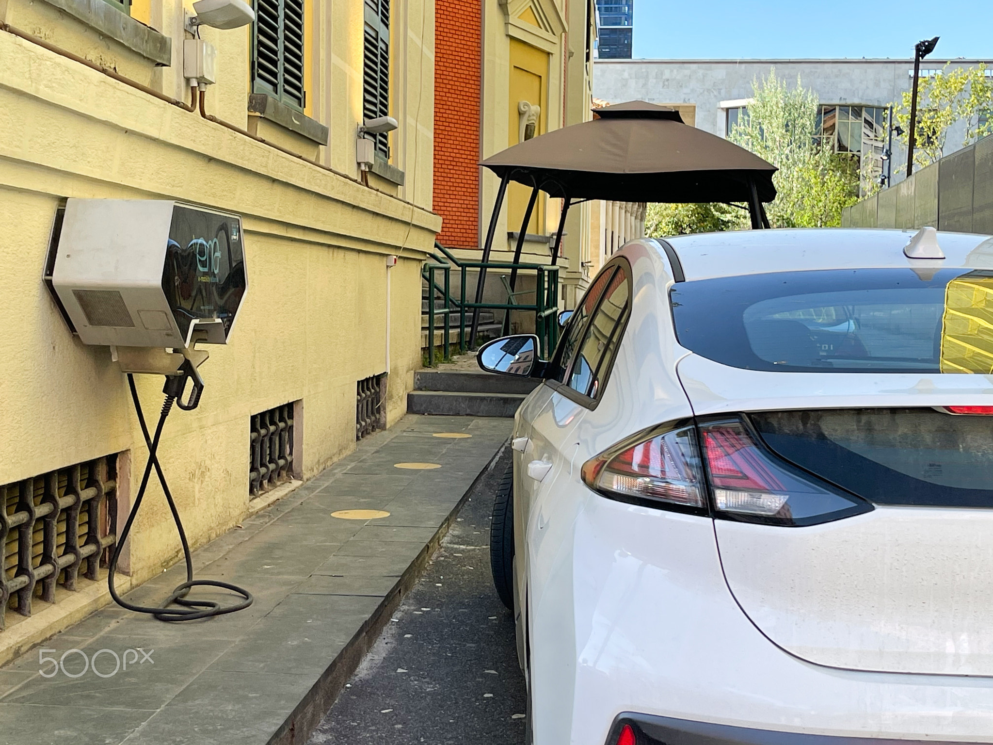 An electric car waiting to be charged with power cable .
