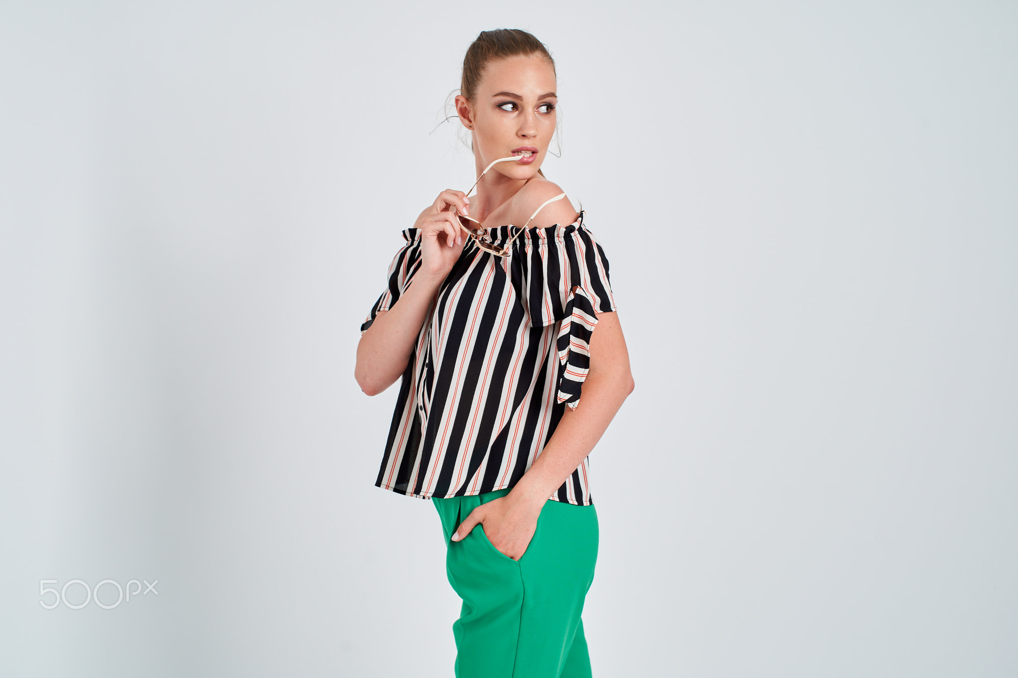 beautiful young girl in striped shirt and green trousers isolated on