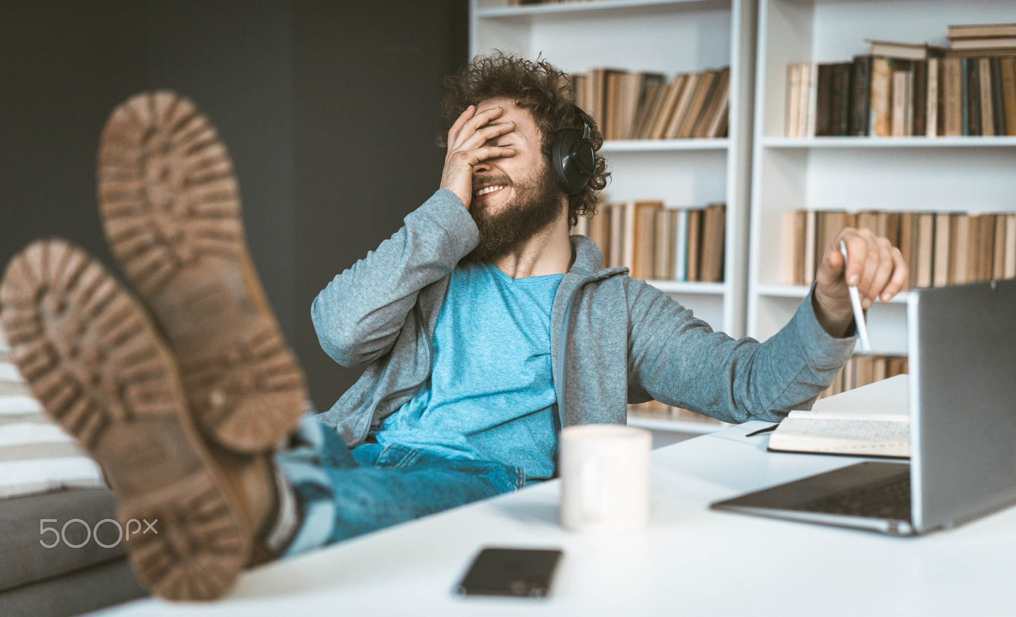 Facepalm. A young programmer works remotely at home. A young man