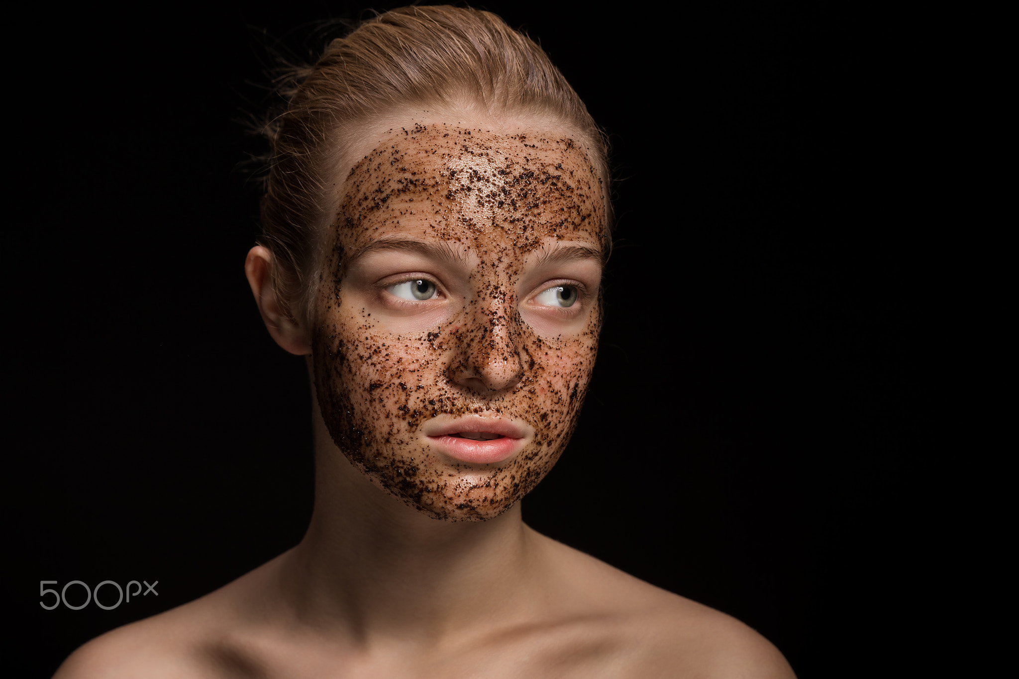 Skin scrub Coffee grounds mask on the face of a beautiful young woman