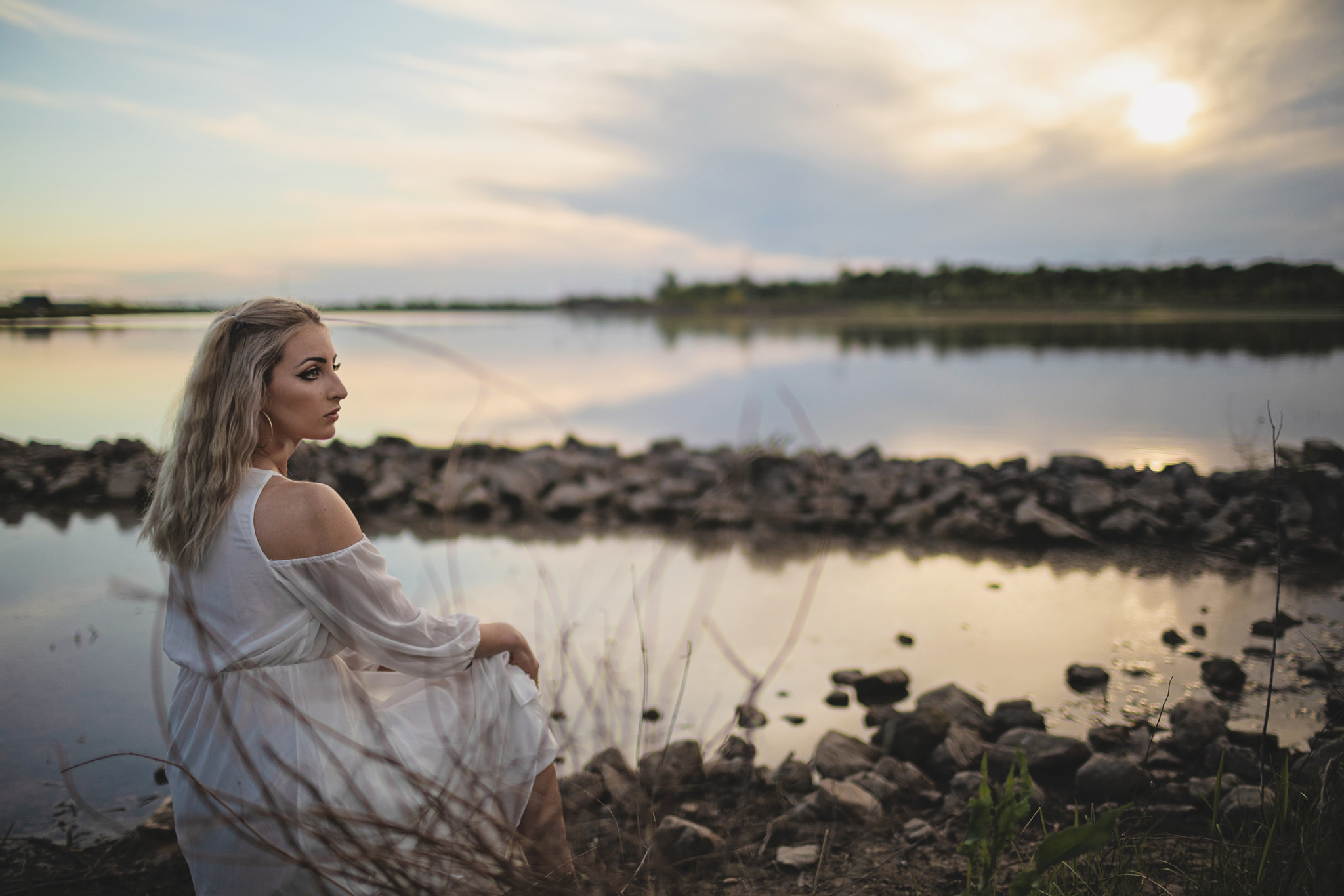 Young Woman Sits Outside by Lake to Watch Sunset, St. Peters, MO, USA