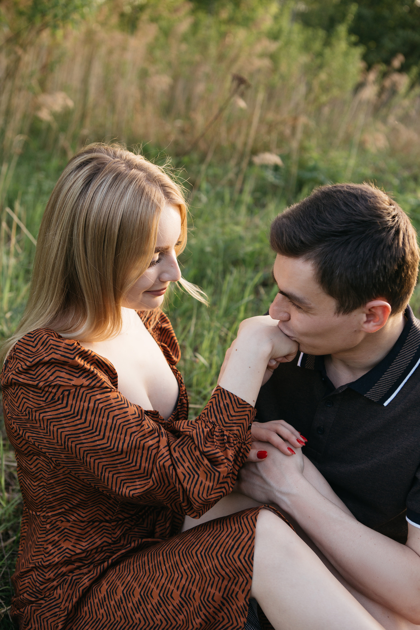 young guy kisses a girl's hand in the Tver park, Russia