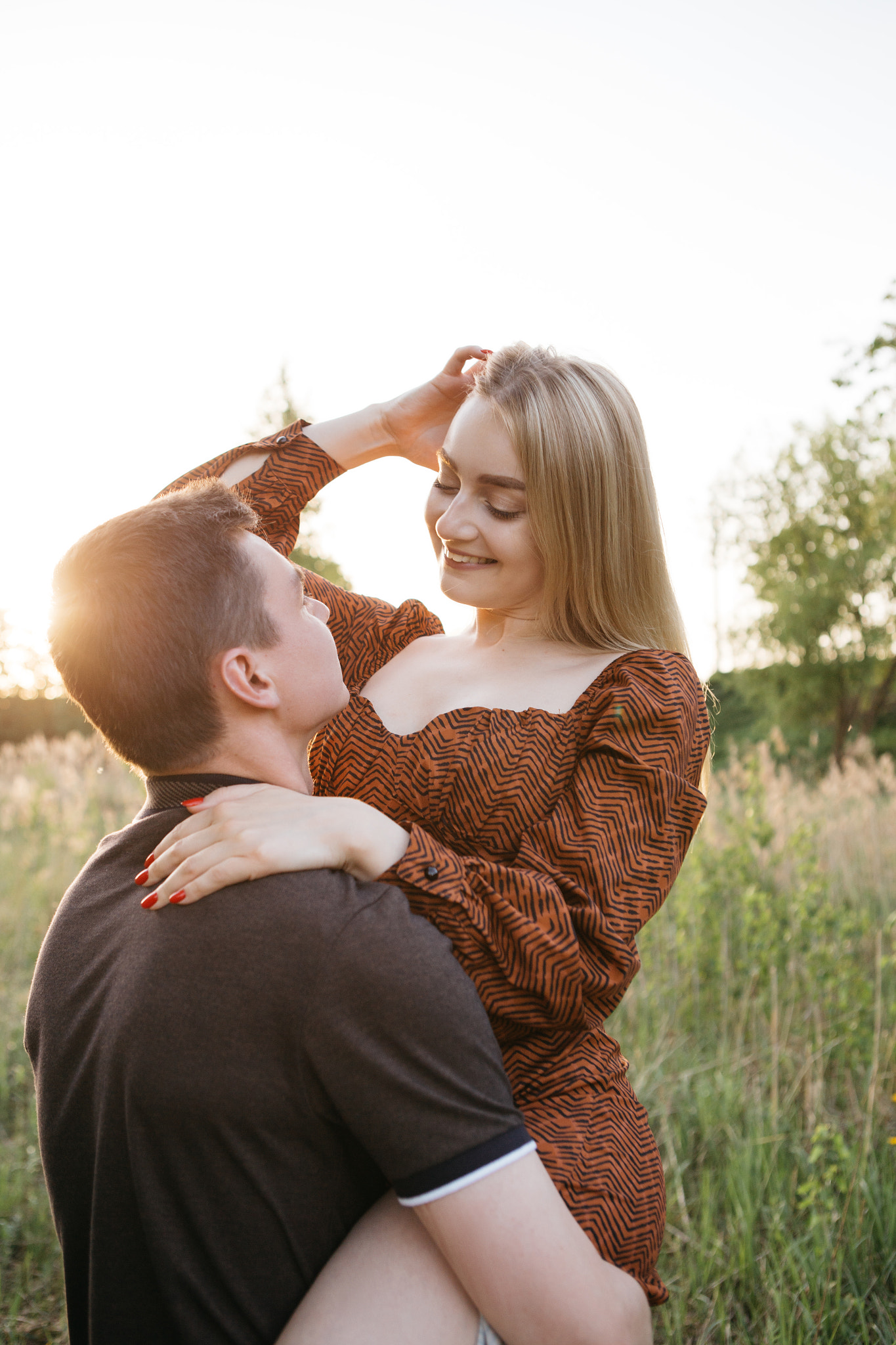 young guy holds a girl in his arms in the park Tver, Russia