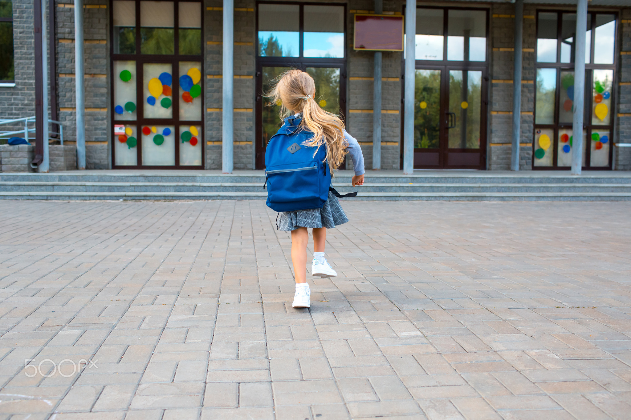 Cute little girl with backpack runs back to school