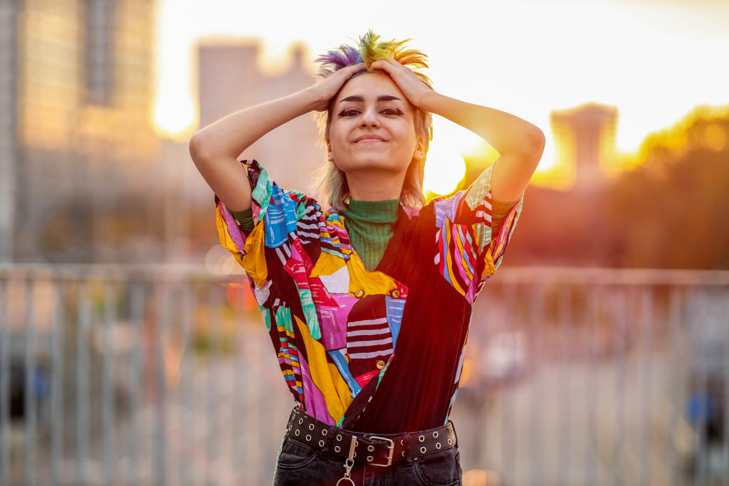 Non-binary person standing on city street at sunset by Edyta Pawlowska on 500px.com