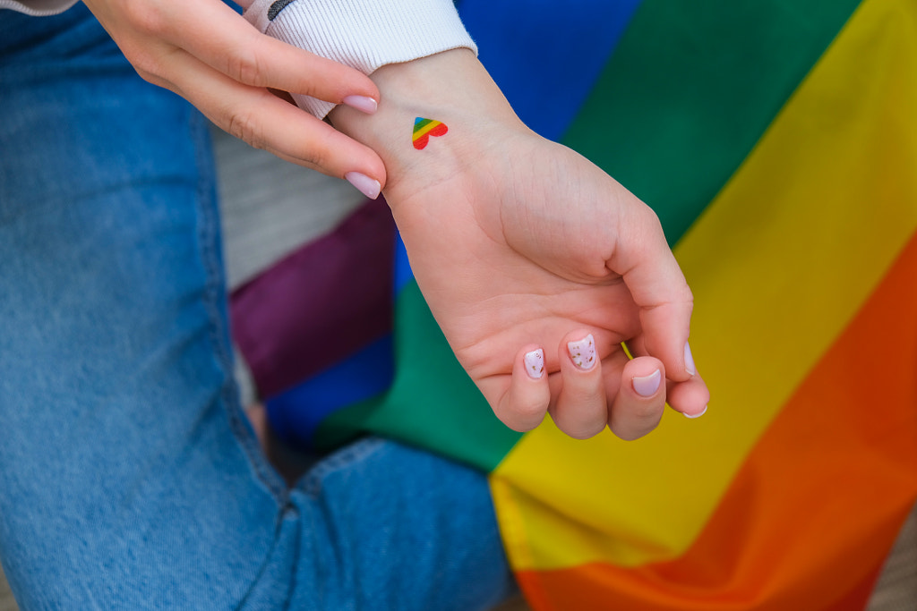 Female hand with rainbow flag in heart shape painted tattoo in wrist by Anastasiia Yanishevska on 500px.com
