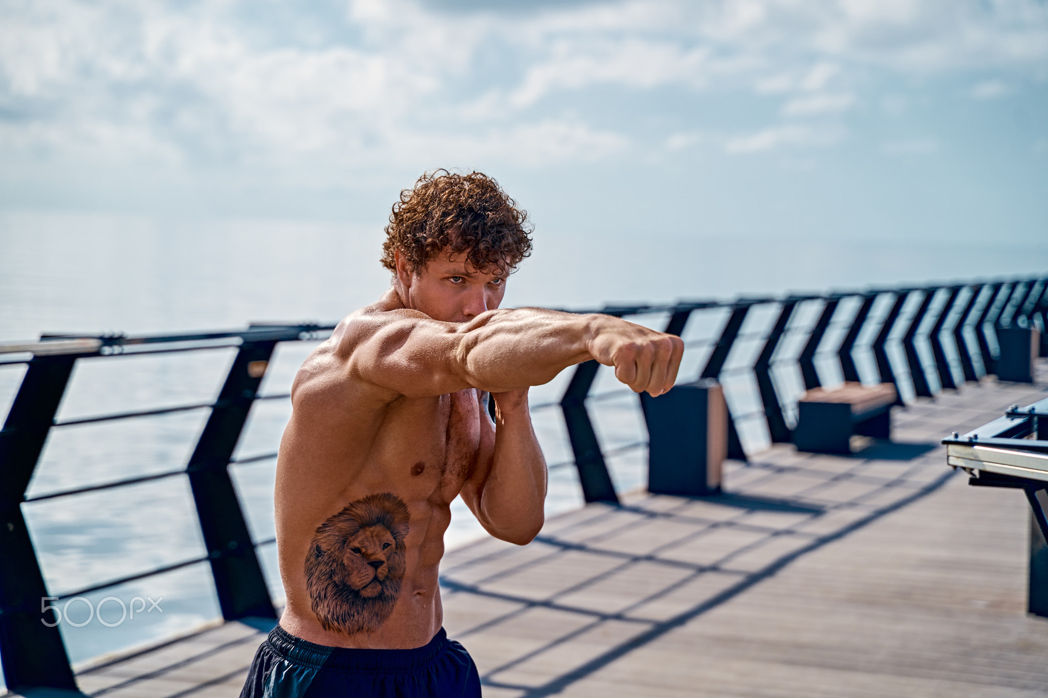 Muscular young man athlete standing and practicing shadow boxing