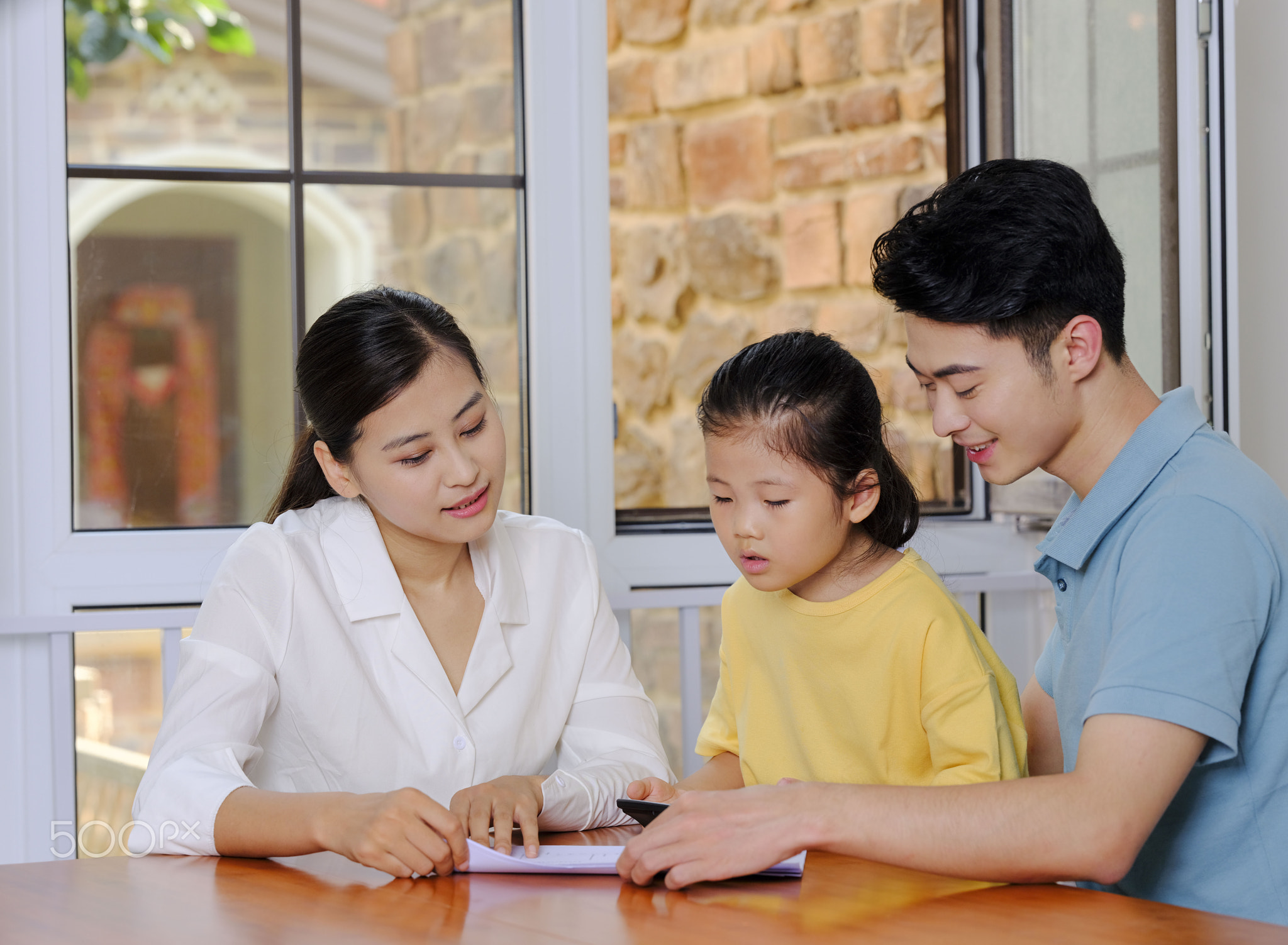 A Happy family of three using calculator