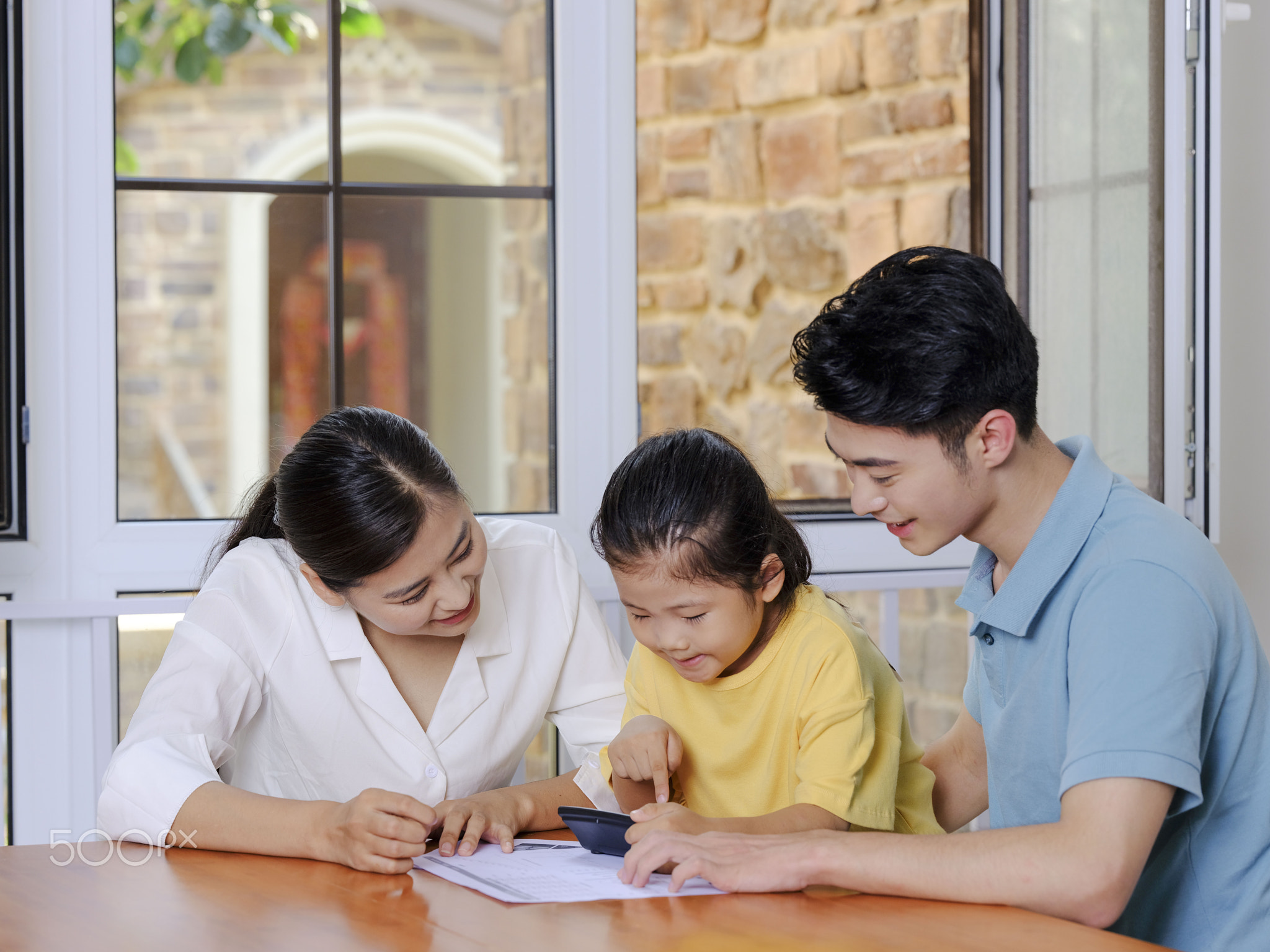 A Happy family of three using calculator