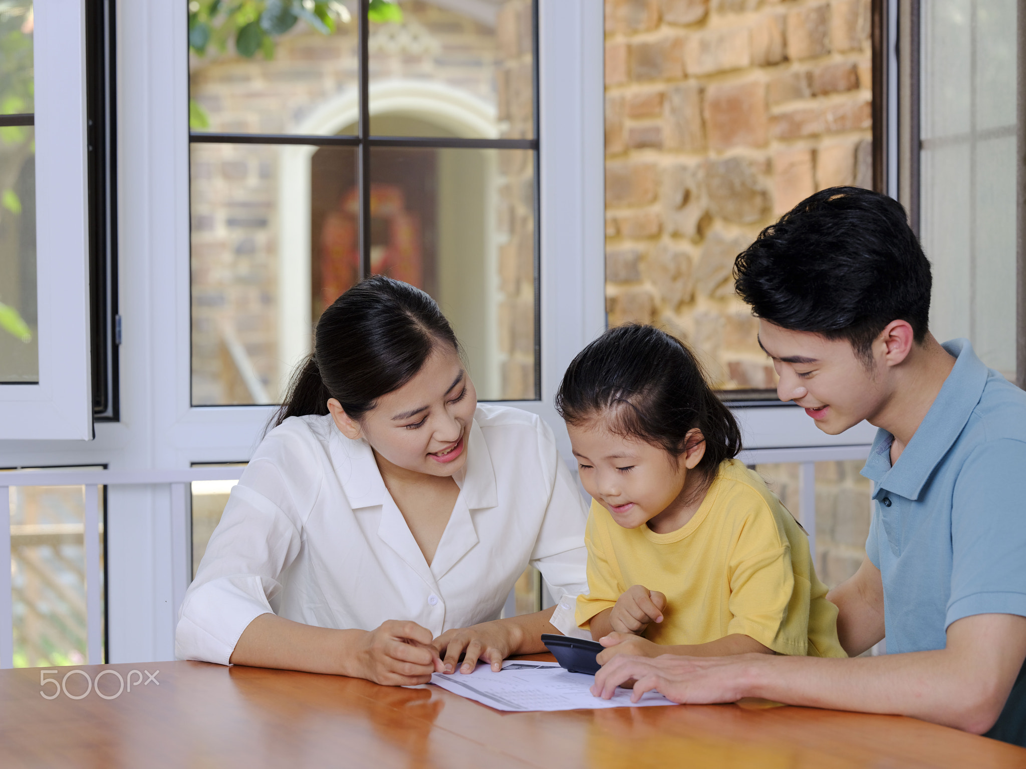 A Happy family of three using calculator