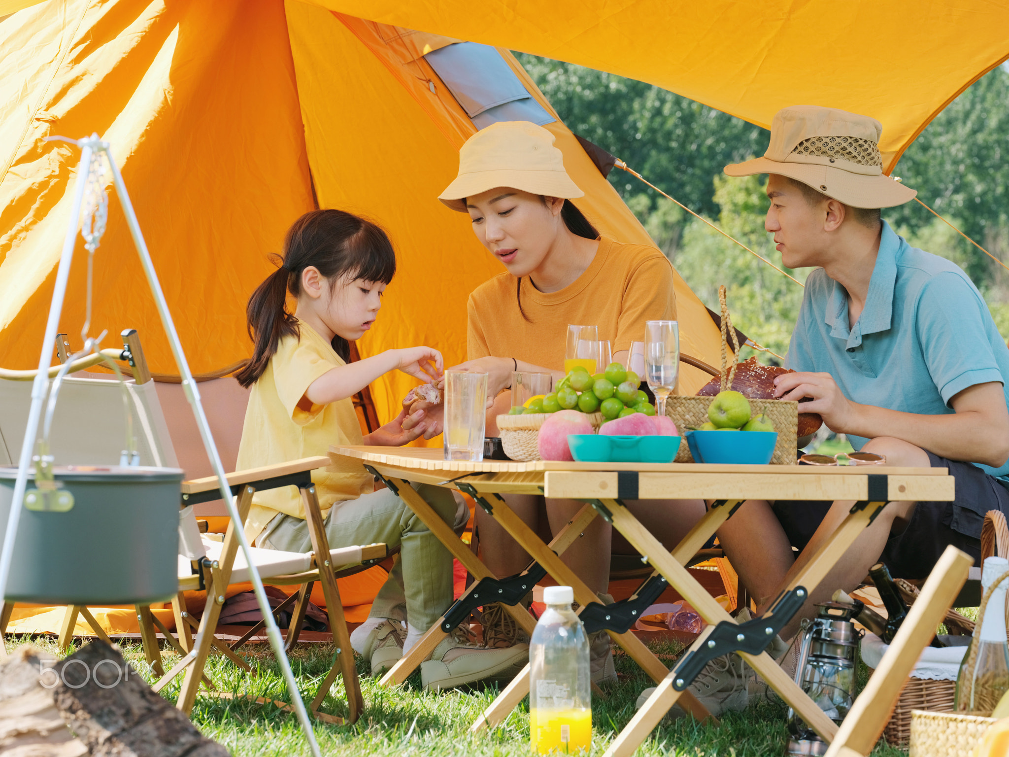 A happy family of three having a picnic outdoors
