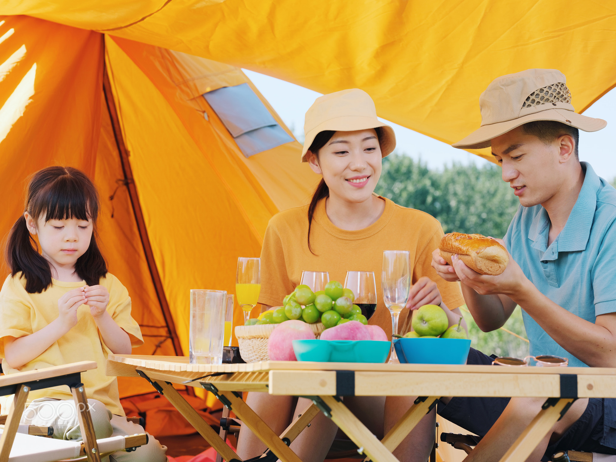 A happy family of three having a picnic outdoors