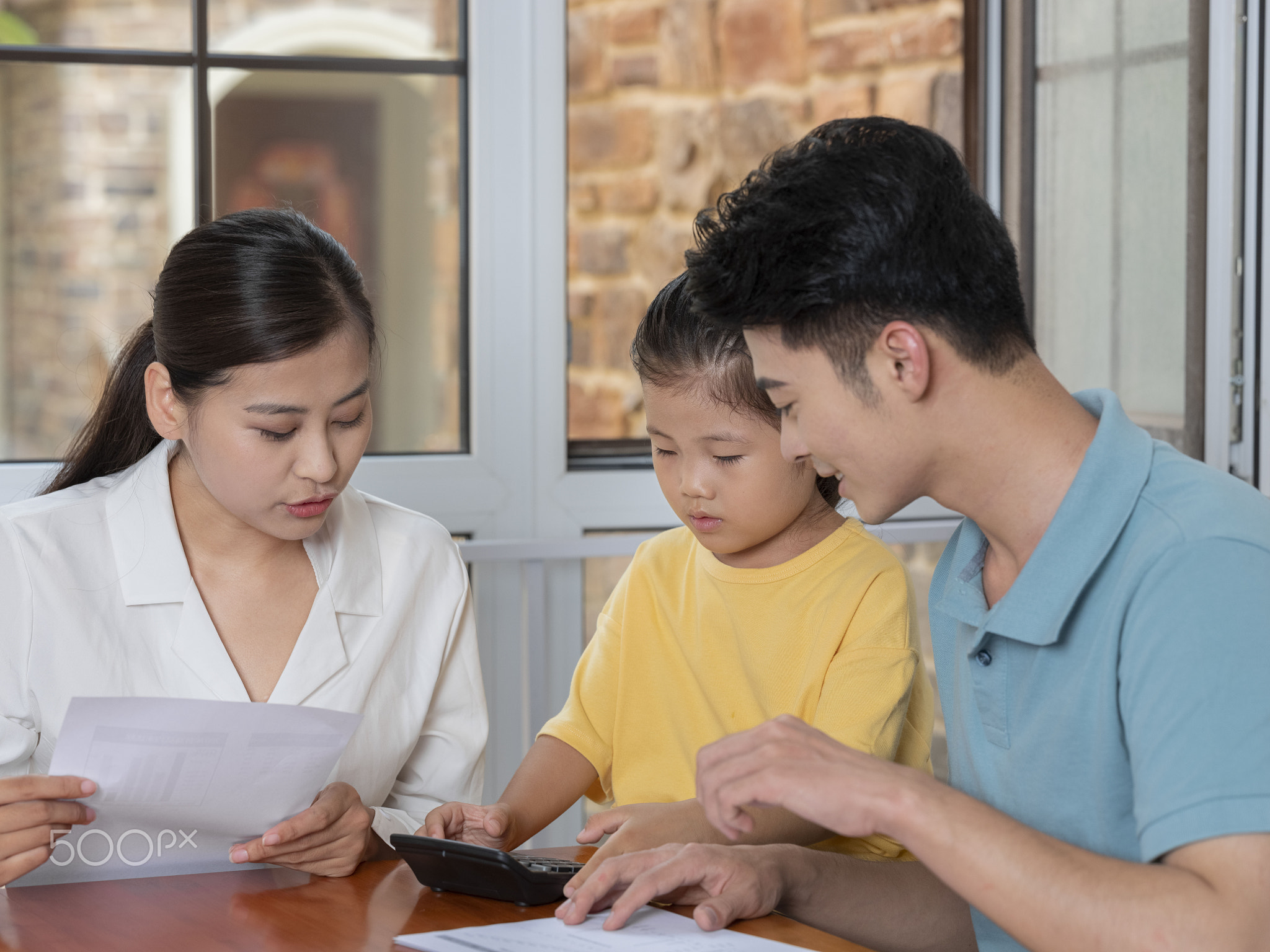 A Happy family of three using calculator