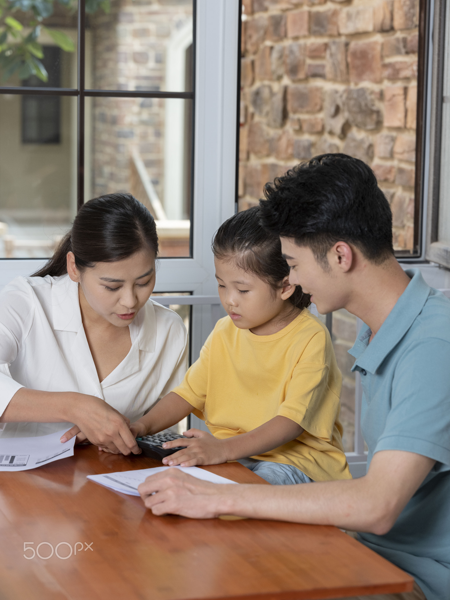 A Happy family of three using calculator