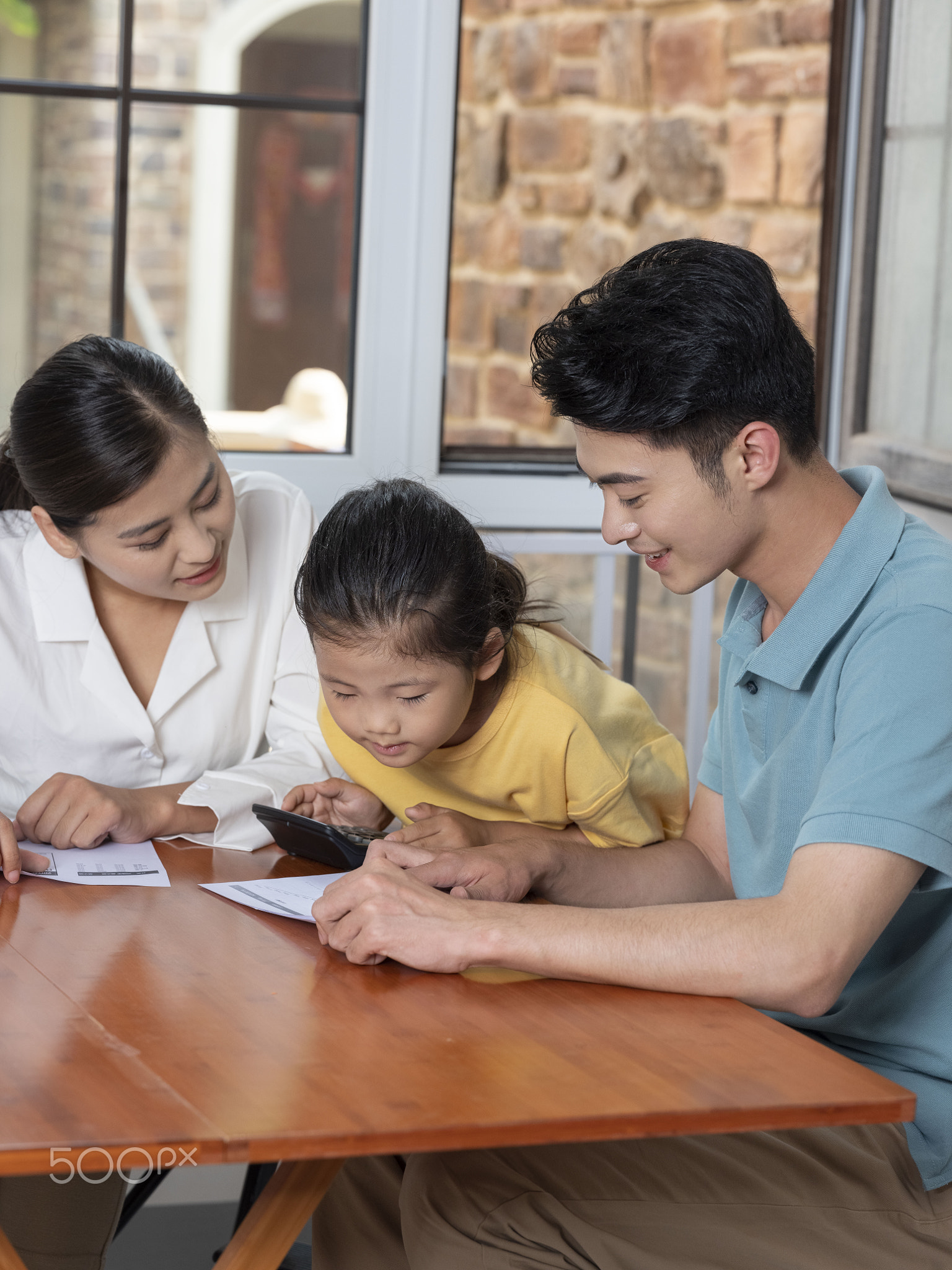 A Happy family of three using calculator