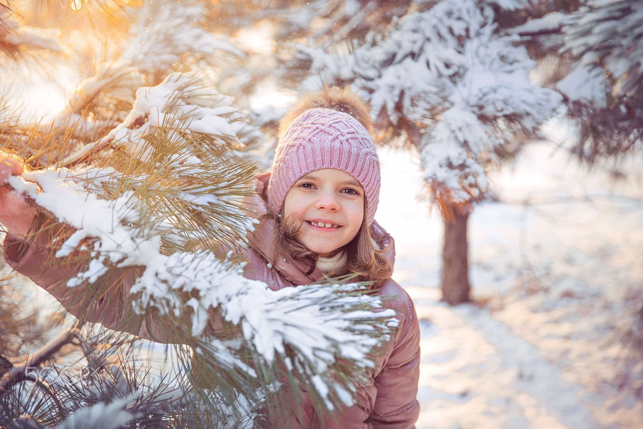 Little girl having fun on sunny beautiful winter day